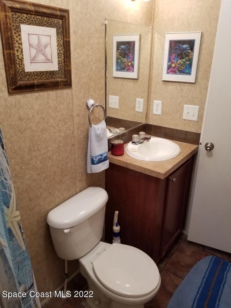4051 Fountain Palm Road Cocoa, FL 32926 - Photo 13 of 25 a bathroom with a toilet a sink and mirror