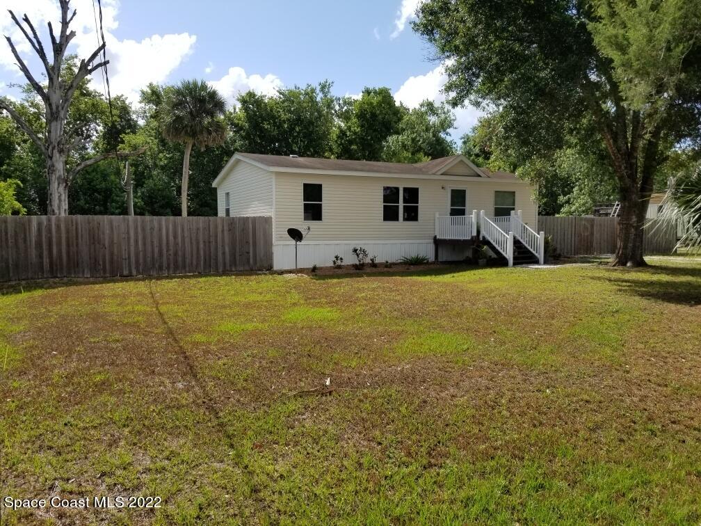 4051 Fountain Palm Road Cocoa, FL 32926 - Photo 2 of 25 a view of a backyard with a white house