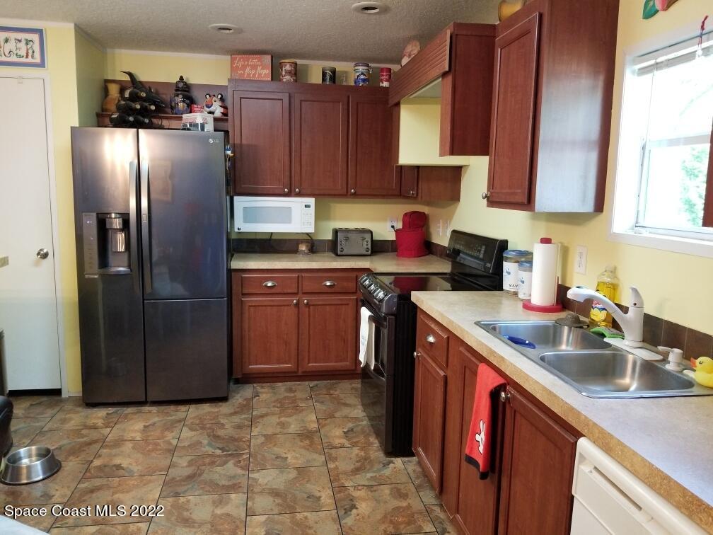 4051 Fountain Palm Road Cocoa, FL 32926 - Photo 8 of 25 a kitchen with stainless steel appliances granite countertop a sink stove and refrigerator