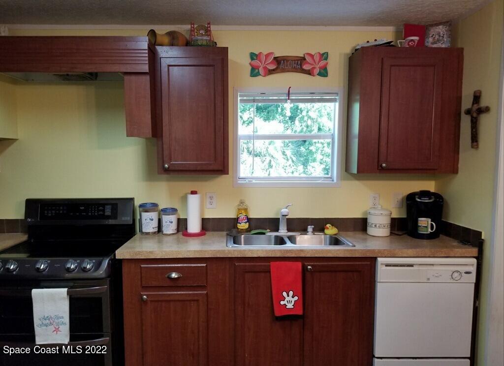 4051 Fountain Palm Road Cocoa, FL 32926 - Photo 10 of 25 a kitchen with stainless steel appliances granite countertop a stove a sink dishwasher and a microwave oven with cabinets