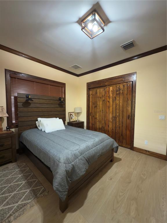 842 Hunting Club Avenue Clewiston, FL 33440 - Photo 11 of 34 a bedroom with a large bed and a chandelier