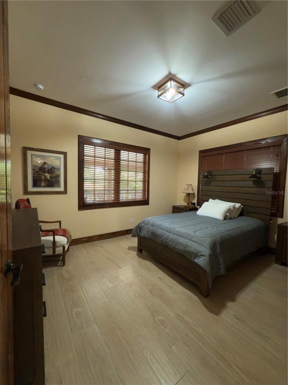 842 Hunting Club Avenue Clewiston, FL 33440 - Photo 13 of 34 a bedroom with a bed and a table in it