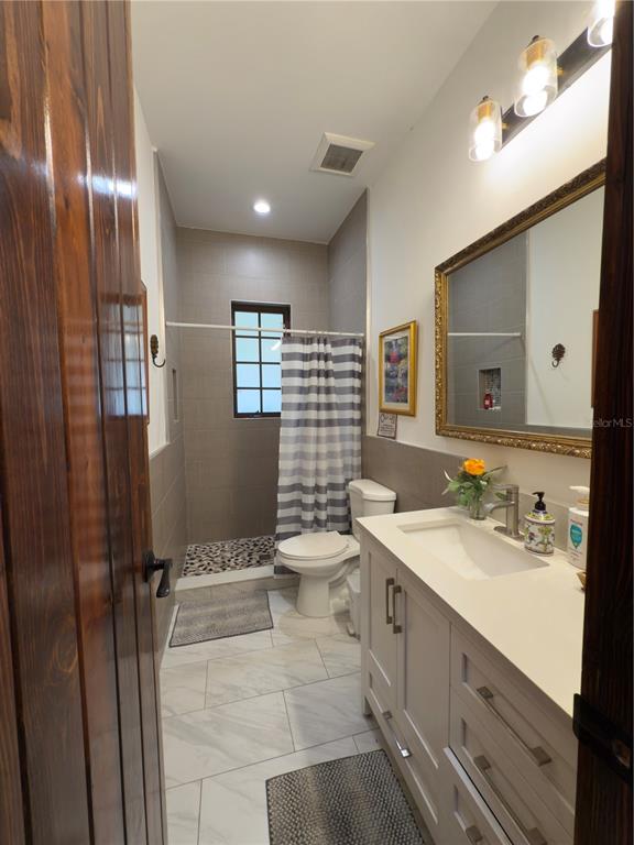 842 Hunting Club Avenue Clewiston, FL 33440 - Photo 16 of 34 a bathroom with a double vanity sink toilet mirror and shower