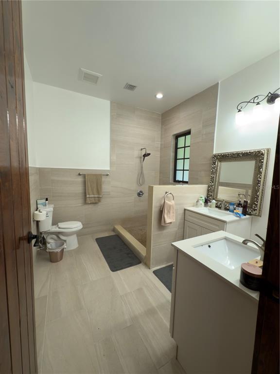 842 Hunting Club Avenue Clewiston, FL 33440 - Photo 19 of 34 a bathroom with a double vanity sink toilet and mirror