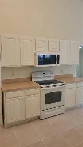 a kitchen with granite countertop white cabinets and stainless steel appliances