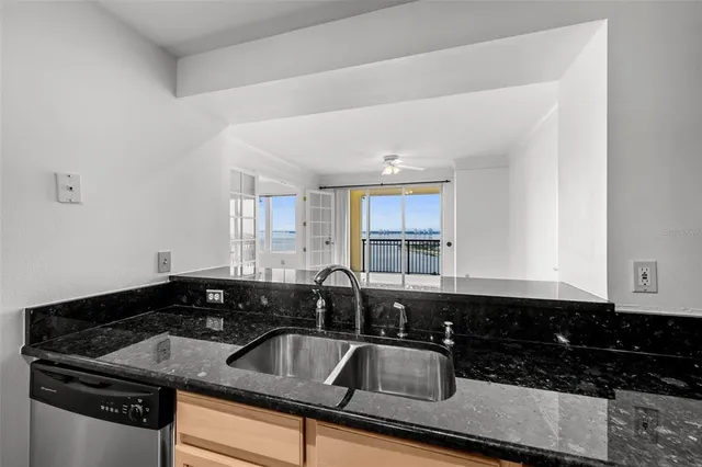 a view of a big room with wooden floor and a kitchen