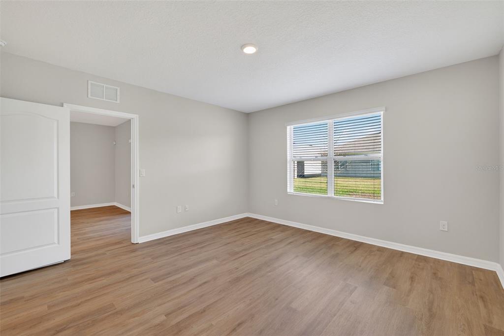 349 Honey Bell Road Winter Haven, FL 33880 - Photo 15 of 29 a view of an empty room with wooden floor and a window