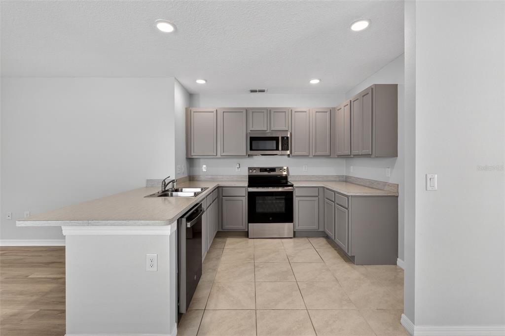 349 Honey Bell Road Winter Haven, FL 33880 - Photo 17 of 29 a kitchen with a sink a counter top space stainless steel appliances and cabinets