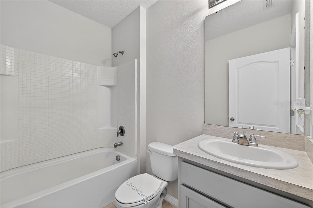 349 Honey Bell Road Winter Haven, FL 33880 - Photo 23 of 29 a bathroom with a granite countertop sink toilet and shower