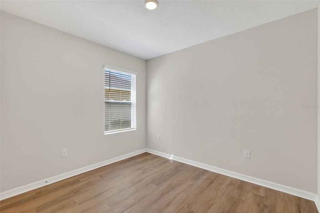349 Honey Bell Road Winter Haven, FL 33880 - Photo 6 of 29 a view of an empty room with wooden floor and a window