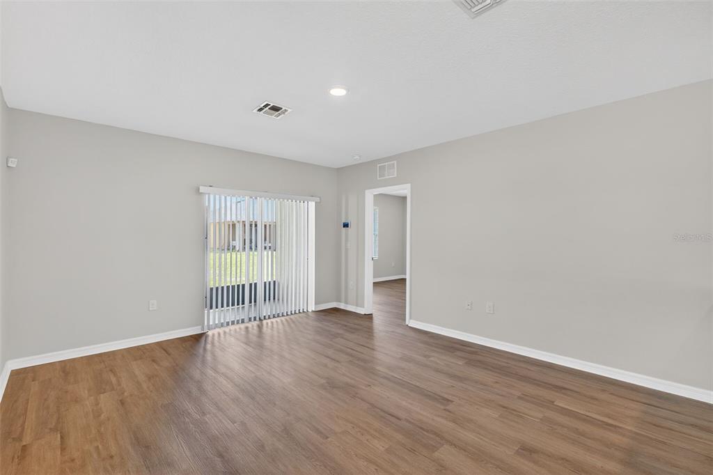 349 Honey Bell Road Winter Haven, FL 33880 - Photo 7 of 29 a view of an empty room with wooden floor