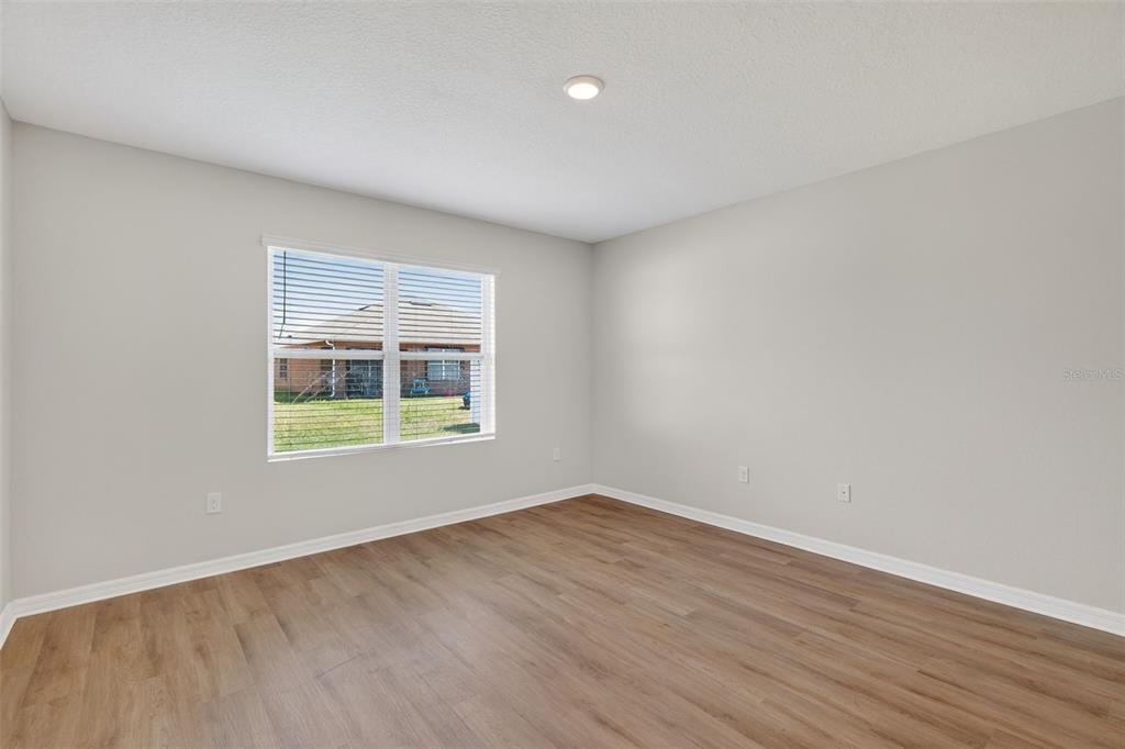 349 Honey Bell Road Winter Haven, FL 33880 - Photo 9 of 29 a view of an empty room with wooden floor and a window