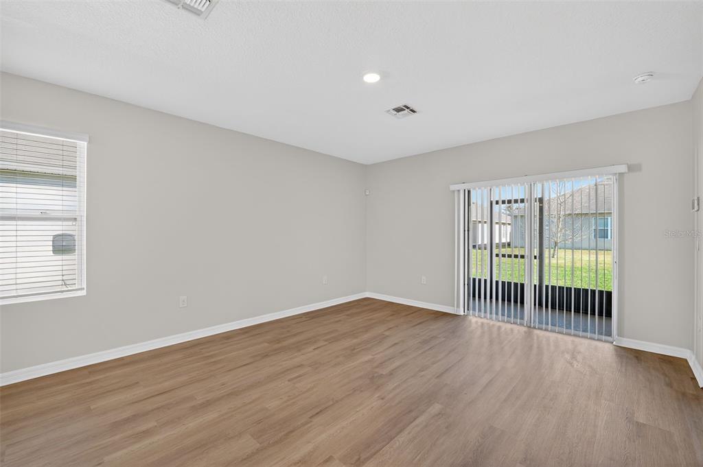 349 Honey Bell Road Winter Haven, FL 33880 - Photo 10 of 29 wooden floor in an empty room with a window
