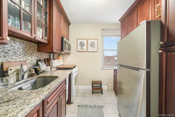 a kitchen with stainless steel appliances granite countertop a refrigerator a sink a stove and a refrigerator
