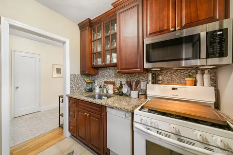 a kitchen with stainless steel appliances granite countertop a sink stove and microwave