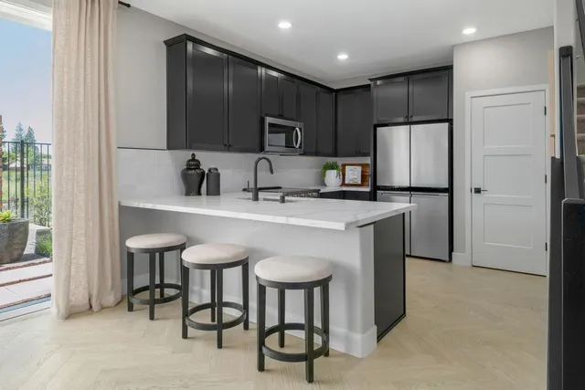 a kitchen with stainless steel appliances a sink stove and refrigerator