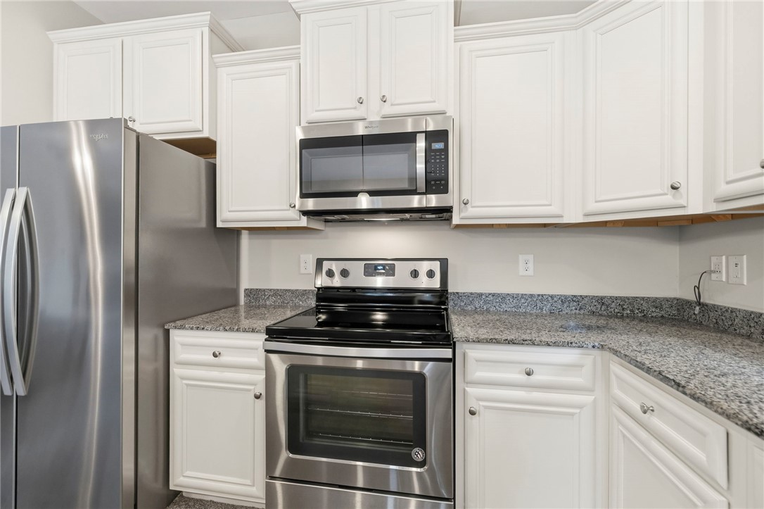 121 Wheaton Court Simpsonville, SC 29680 - Photo 17 of 40 This modern kitchen features sleek appliances, ample counter space, and crisp cabinetry for culinary pursuits.