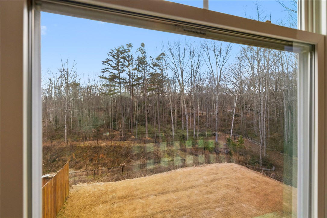 121 Wheaton Court Simpsonville, SC 29680 - Photo 29 of 40 This captivating view through a window reveals a serene natural landscape with mature trees.