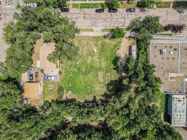 an aerial view of residential house with outdoor space and trees all around