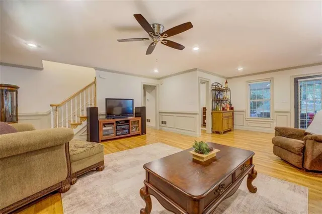 a living room with furniture and a dining table with wooden floor