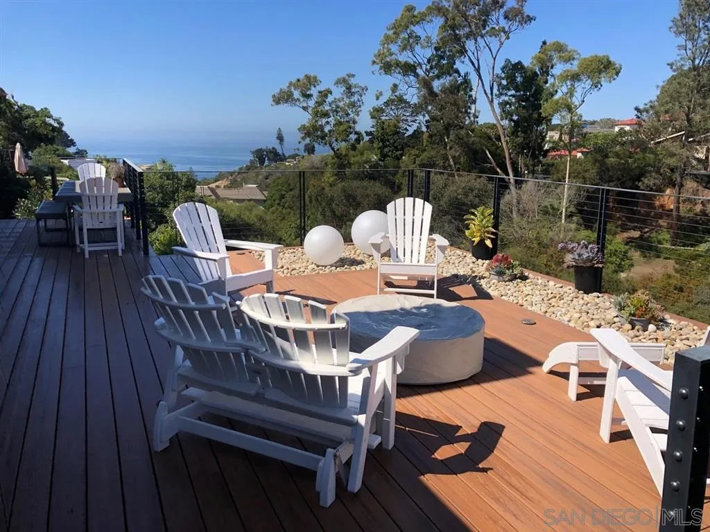 1402 Rodeo Drive La Jolla, CA 92037 - Photo 12 of 62 a view of a roof deck with table and chairs with wooden floor and fence