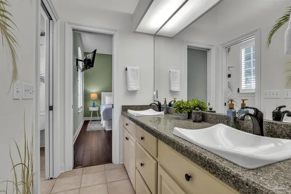 a bathroom with a granite countertop sink and a mirror