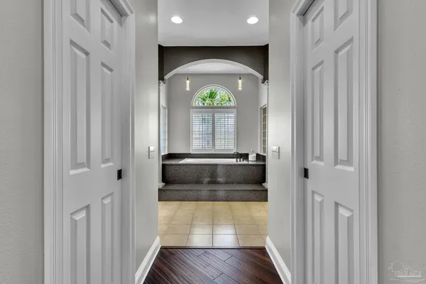 a kitchen with granite countertop white cabinets white appliances a sink and a window