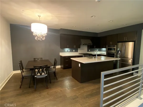a kitchen with a dining table chairs and a refrigerator