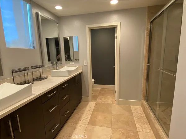 a spacious bathroom with a double vanity sink a mirror and a shower