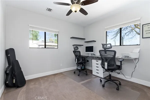 a view of a workspace with furniture and a window