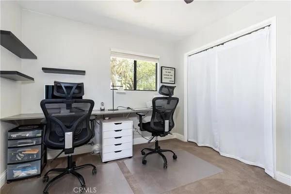 a view of a workspace with furniture and a window