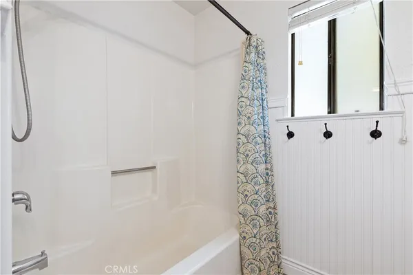 a bathroom with a shower curtain and a window