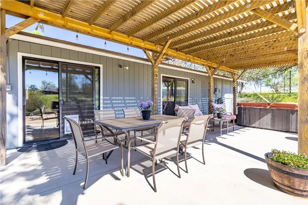 a view of a patio with table and chairs potted plants with floor to ceiling window and potted plants