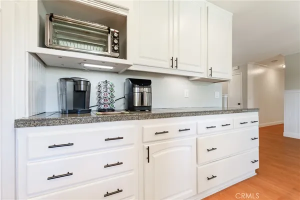 a kitchen with granite countertop white cabinets and stainless steel appliances