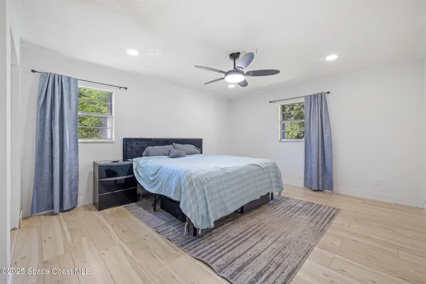 a bedroom with a large bed and a chandelier