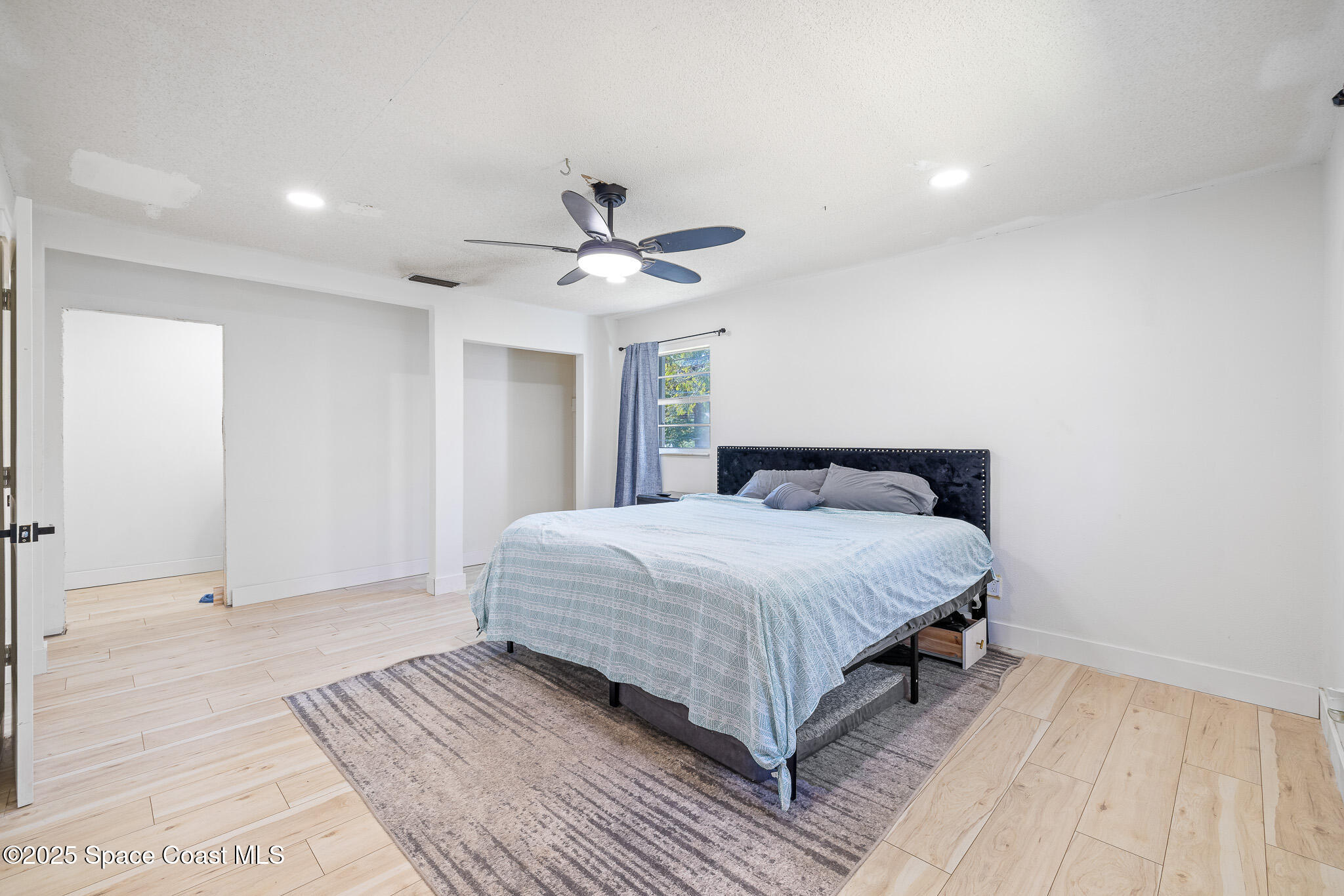 1274 Cimarron Circle Northeast Palm Bay, FL 32905 - Photo 13 of 37 a spacious bedroom with a bed and a ceiling fan
