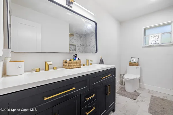 a bathroom with a granite countertop sink a toilet and a mirror