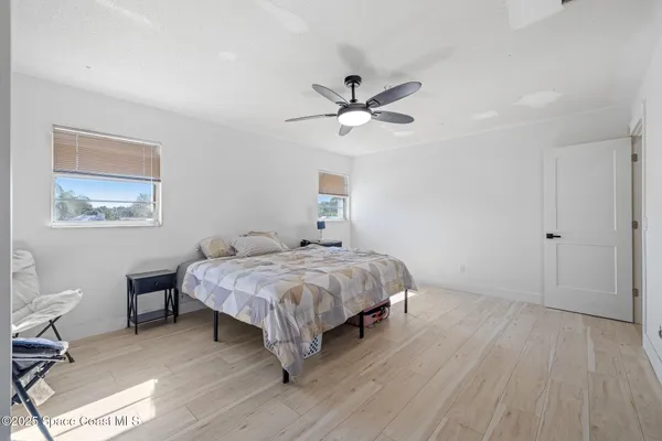 a bedroom with a bed chandelier and a window
