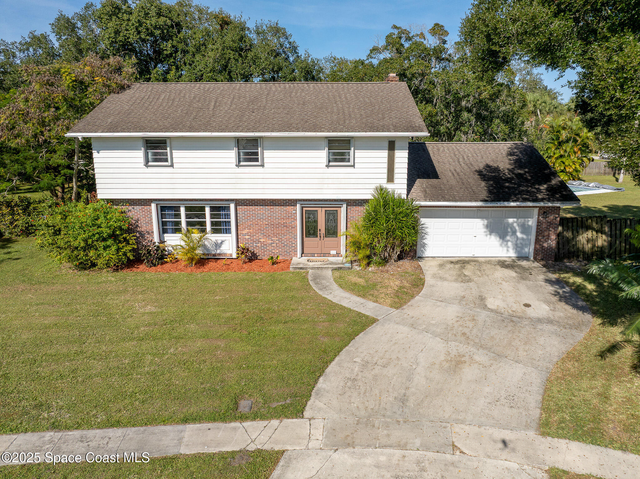1274 Cimarron Circle Northeast Palm Bay, FL 32905 - Photo 2 of 37 a front view of a house with garden