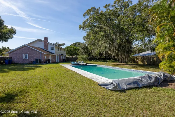 an aerial view of a house with a yard and lake view