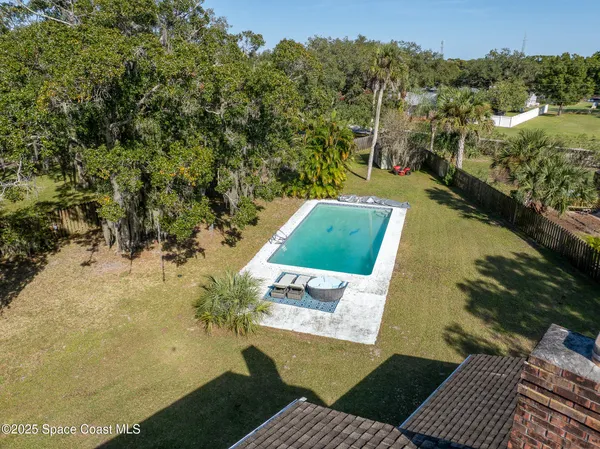a aerial view of a house with a yard table and chairs