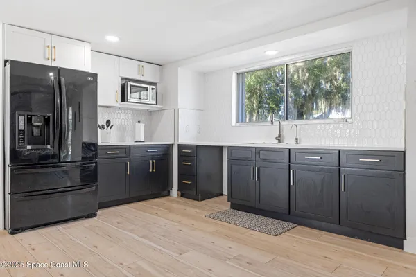 a kitchen with stainless steel appliances granite countertop a refrigerator and a sink