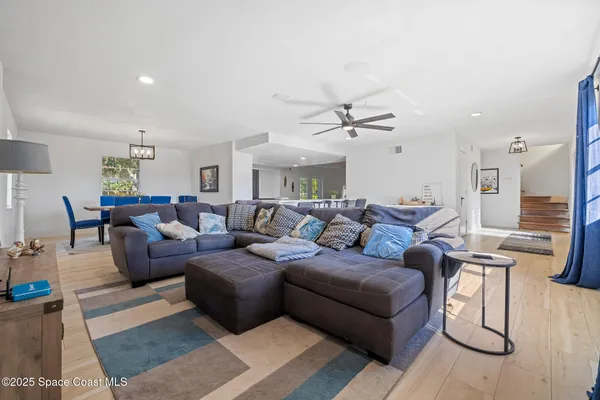 a living room with furniture and a view of kitchen