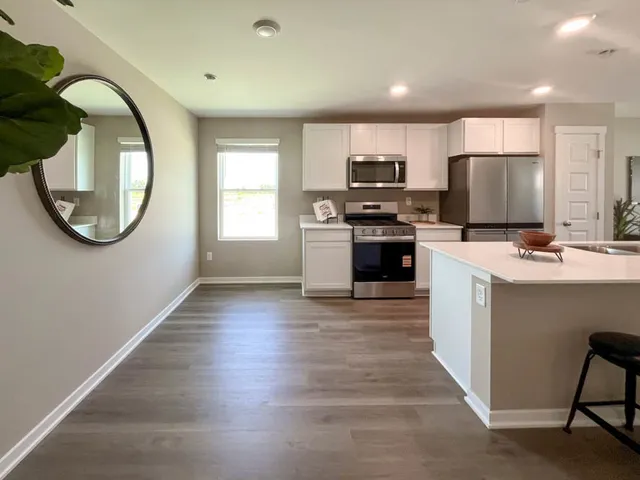 a kitchen with stainless steel appliances a stove a sink a refrigerator and a microwave