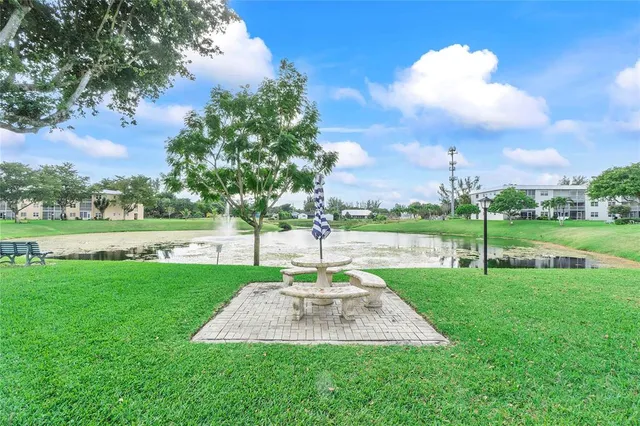 a park view with a fountain and a big yard