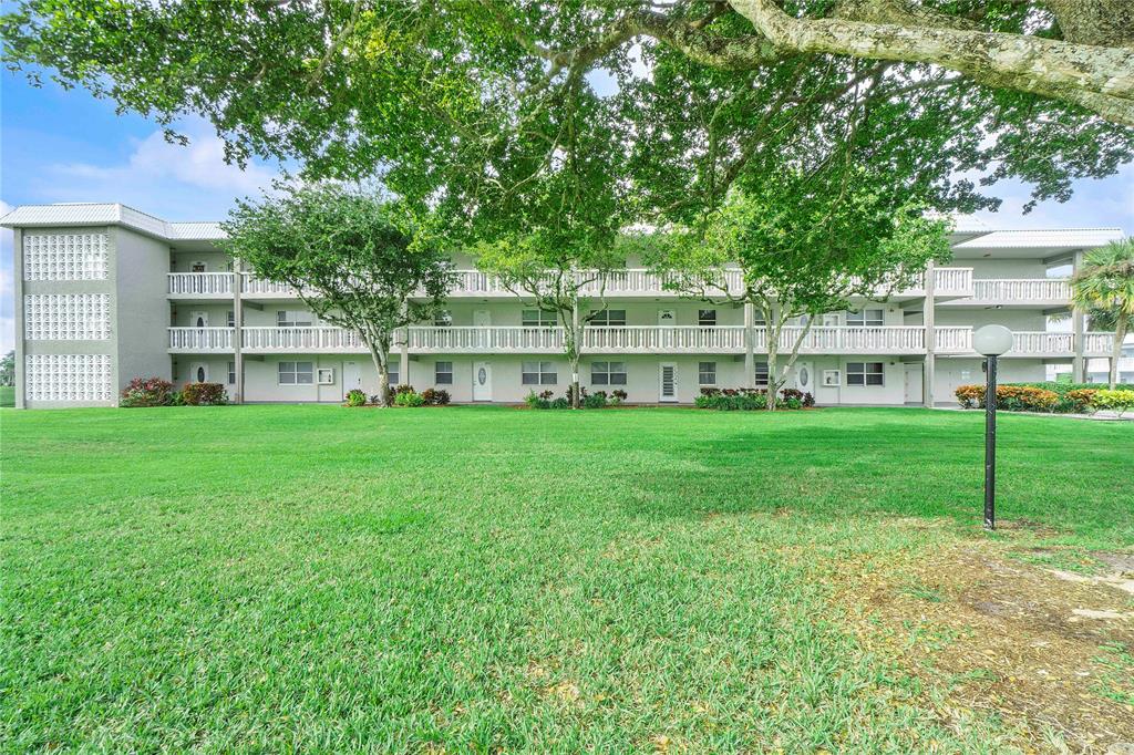 9856 Marina Boulevard, Unit 1311 Boca Raton, FL 33428 - Photo 21 of 26 a view of a house with a big yard and large trees