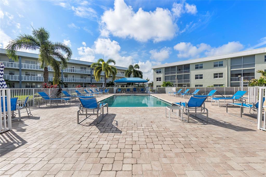 9856 Marina Boulevard, Unit 1311 Boca Raton, FL 33428 - Photo 24 of 26 a view of a patio with dining table and chairs with wooden fence