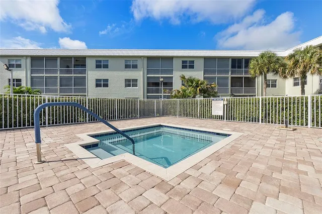 a view of a house with a small yard and wooden fence
