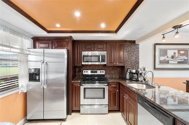 a kitchen with stainless steel appliances granite countertop a refrigerator and a stove