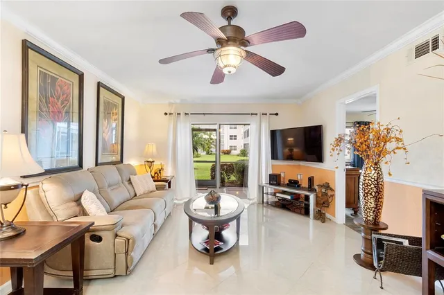 a living room with furniture a flat screen tv and a large window